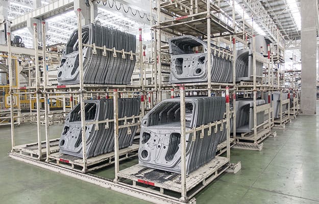 Automobile doors stored on racks in an auto factory setting.
