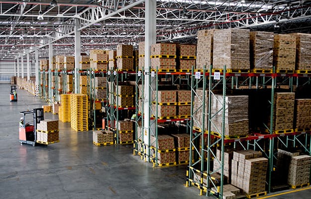 Large modern warehouse with goods arranged in racks.