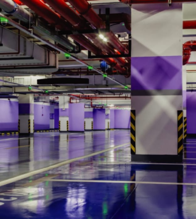 Image of a spacious car parking area with metal water and gas pipelines.